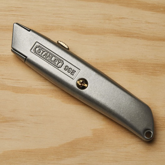 6 inch Classic 99 retractable utility knife placed on wooden surface.

