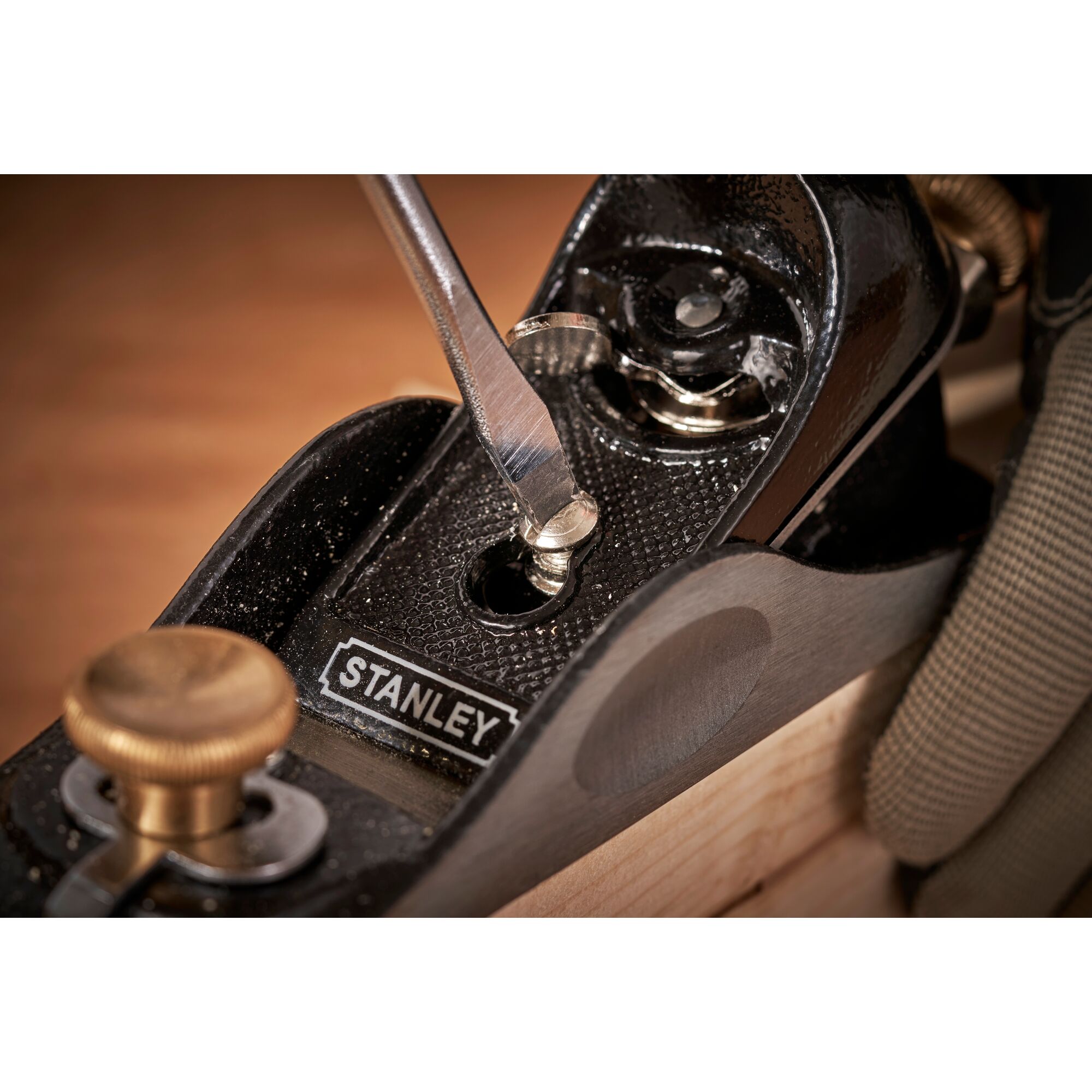 STANLEY 12-020 hand plane close-up, screwdriver adjusting blade, woodworking tool in use.