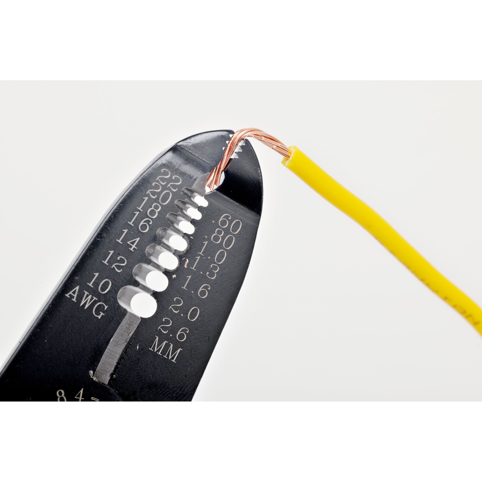 STANLEY 84-475-22 wire stripper tool close-up with yellow insulated wire, photography on white background.