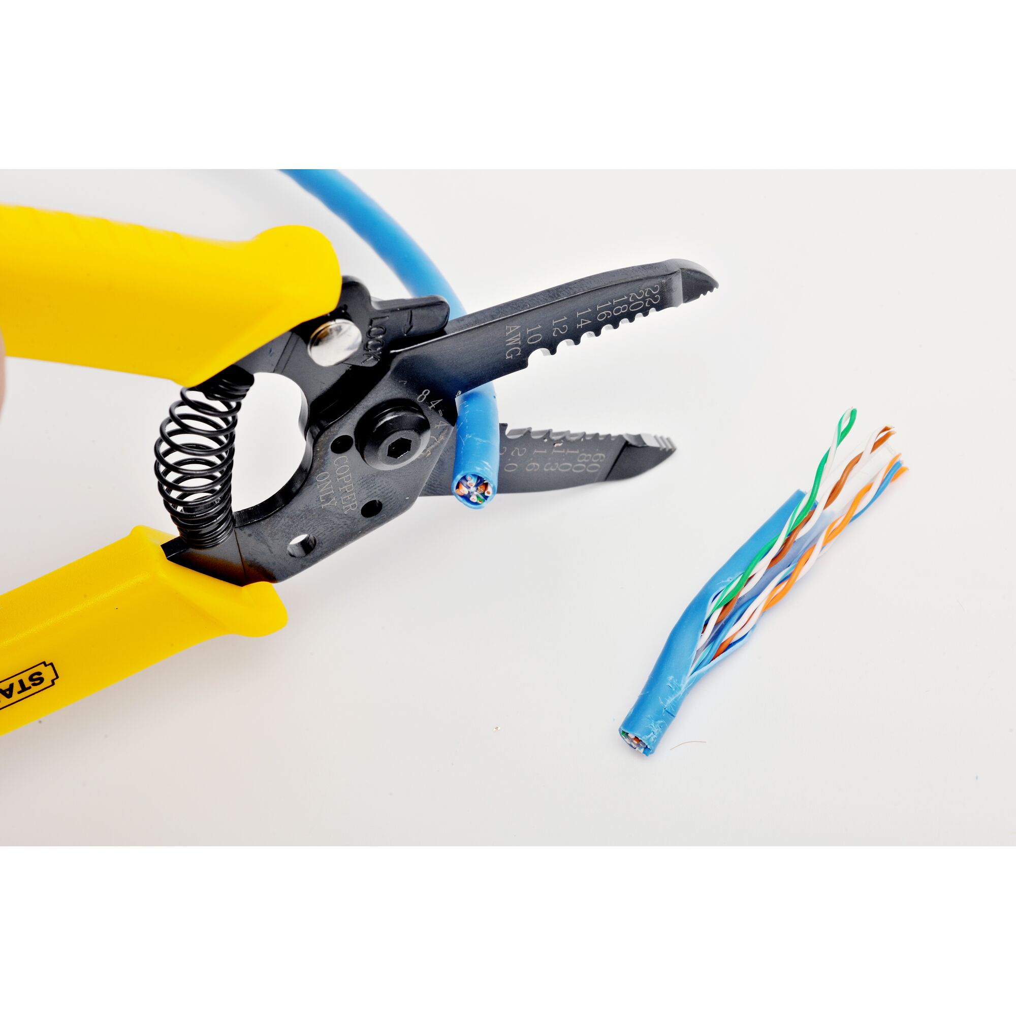 Stanley 84-475-22 wire stripper tool with yellow handles cutting blue cable, close-up on white background.