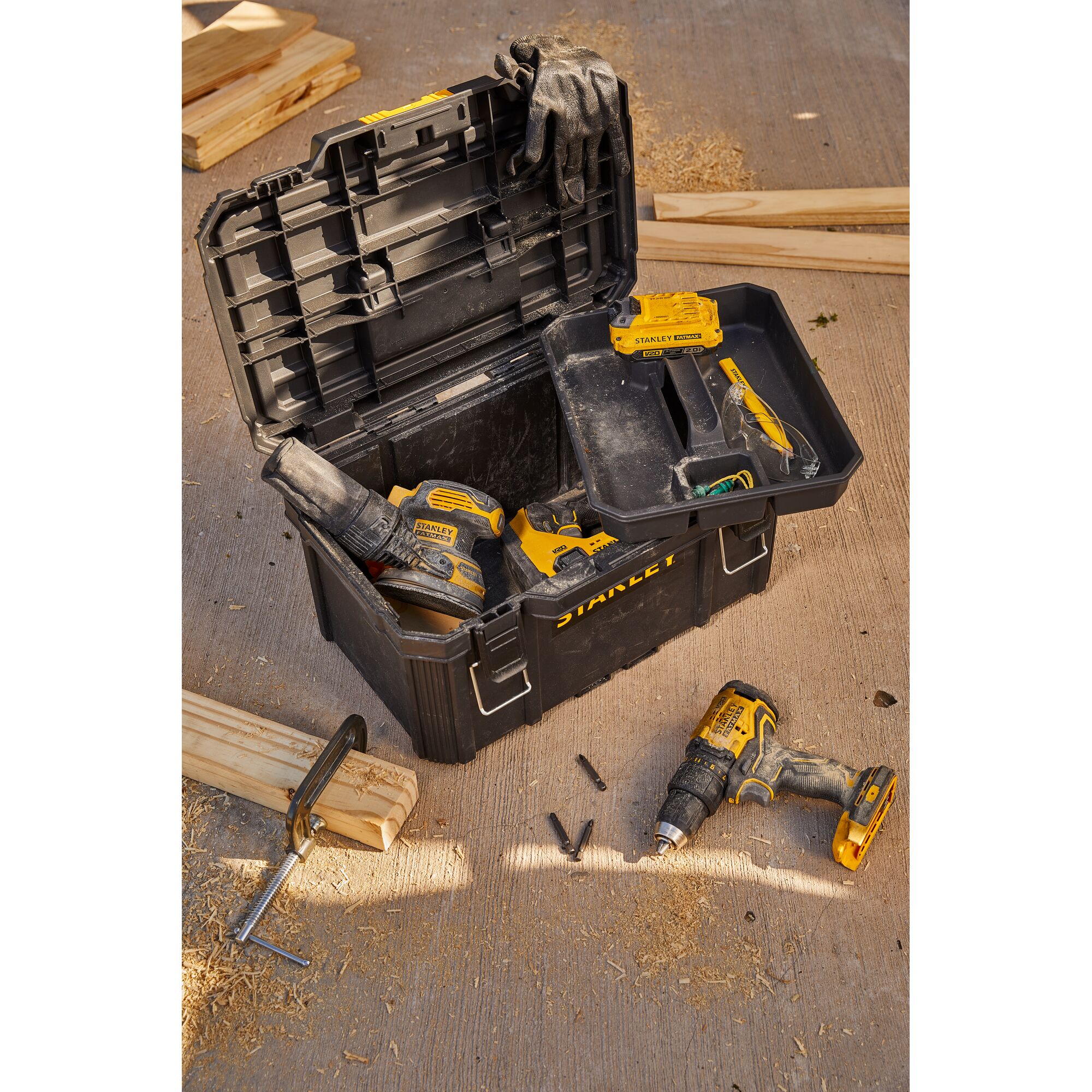 STANLEY SB202 black toolbox with tools and glove, top angle, on workshop floor.