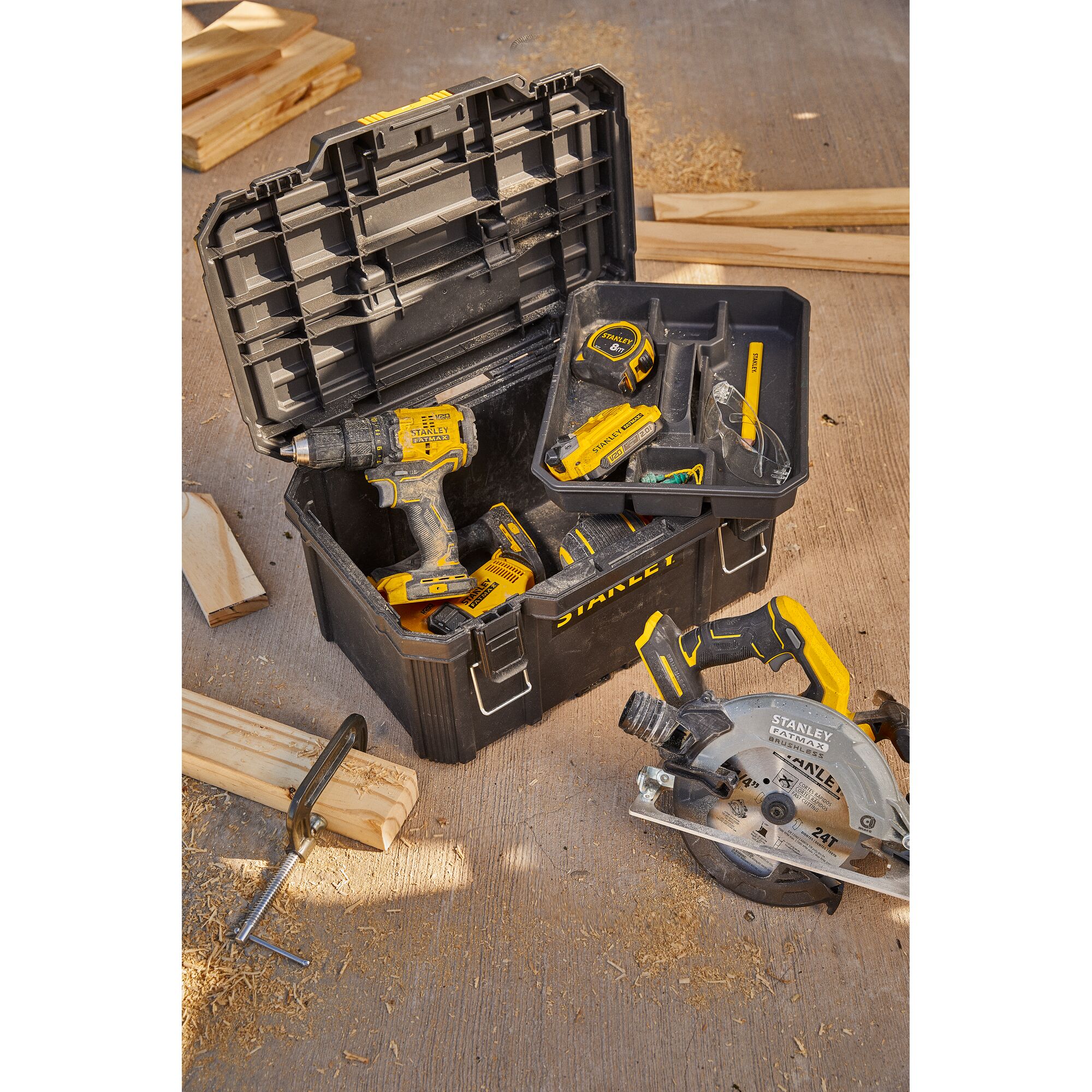 Photo of STANLEY SB202 tool box with drill, tape measure, and circular saw on workshop floor, angled view.