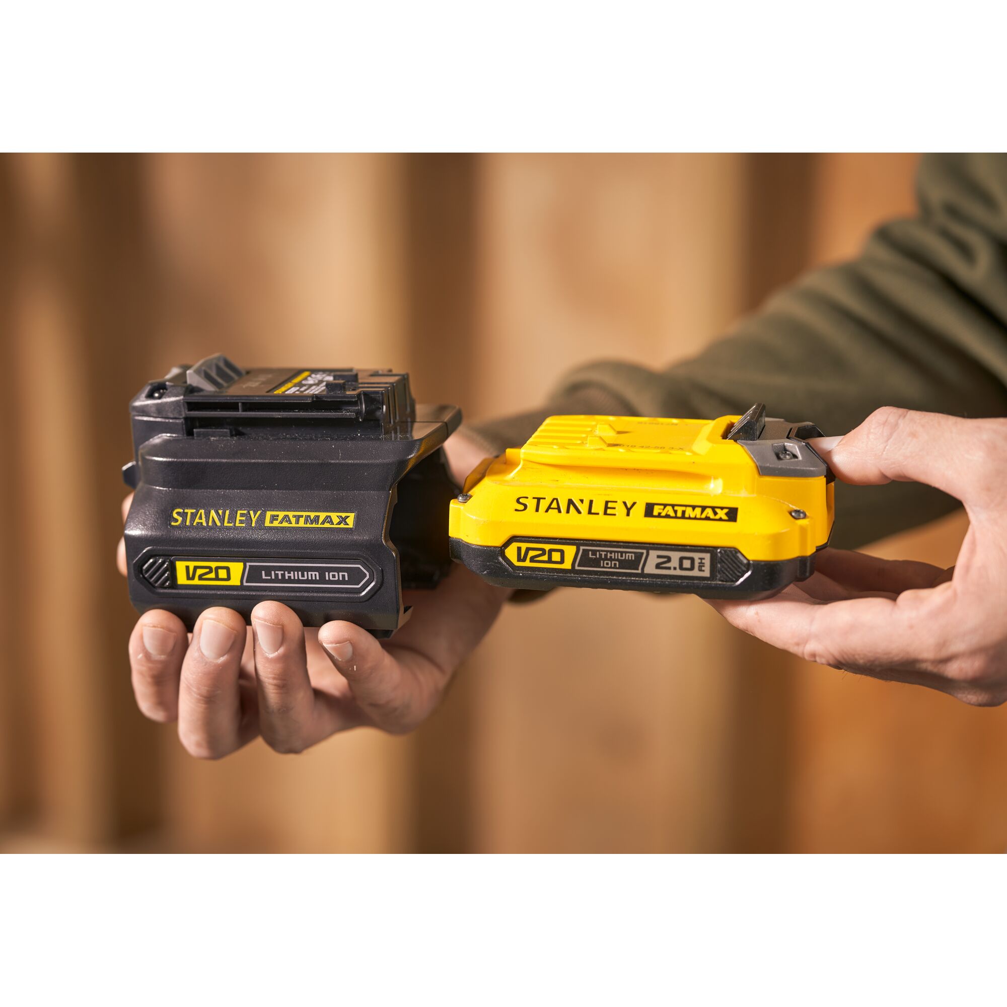 Photo of STANLEY SBA100 V20 FATMAX lithium ion batteries, black and yellow, held in hand.