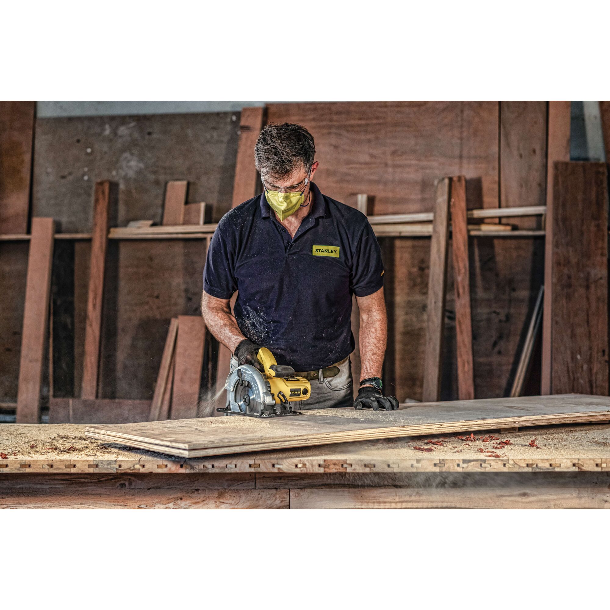 Stanley SC16 circular saw in use on wood in workshop, operator wearing Stanley shirt.