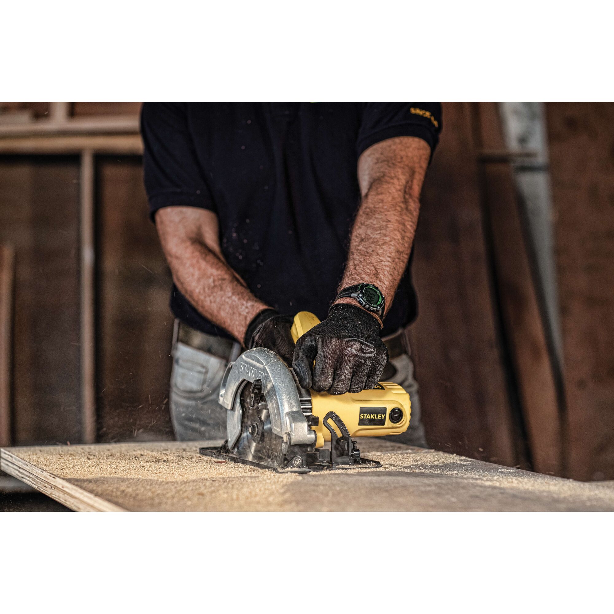 Photo of STANLEY SC16 circular saw in use, cutting wood, yellow body visible in workshop setting.