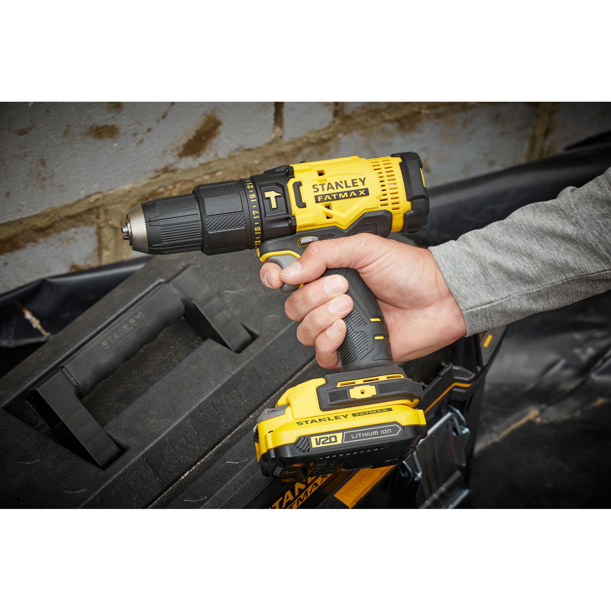 Photo of STANLEY SCD711C1H-B2 corded drill held in hand, yellow and black, with toolbox in background.