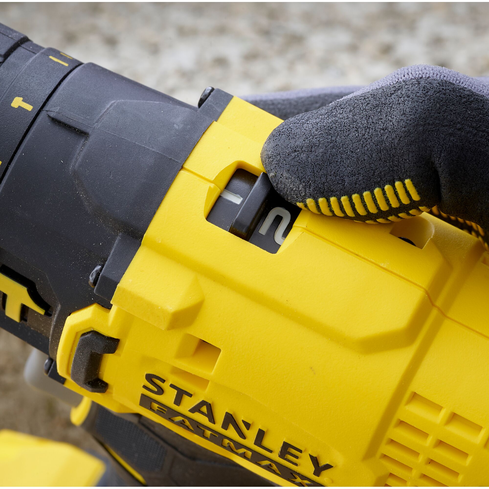 Photo of STANLEY SCD711C1H-B2 power tool speed switch, yellow and black close-up, user hand operating.