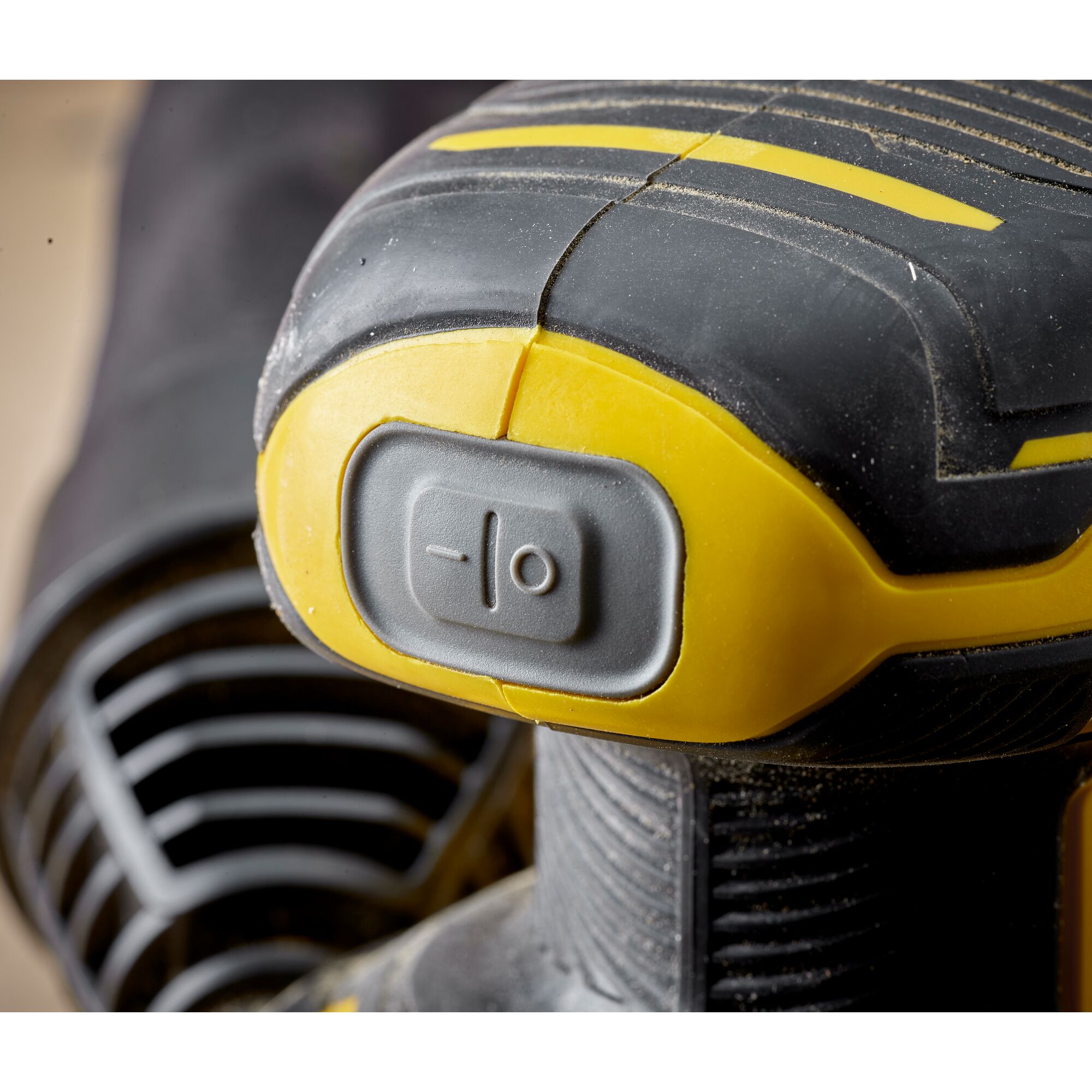 STANLEY SCS220B sander close-up showing grey power switch, yellow and black textured grip.