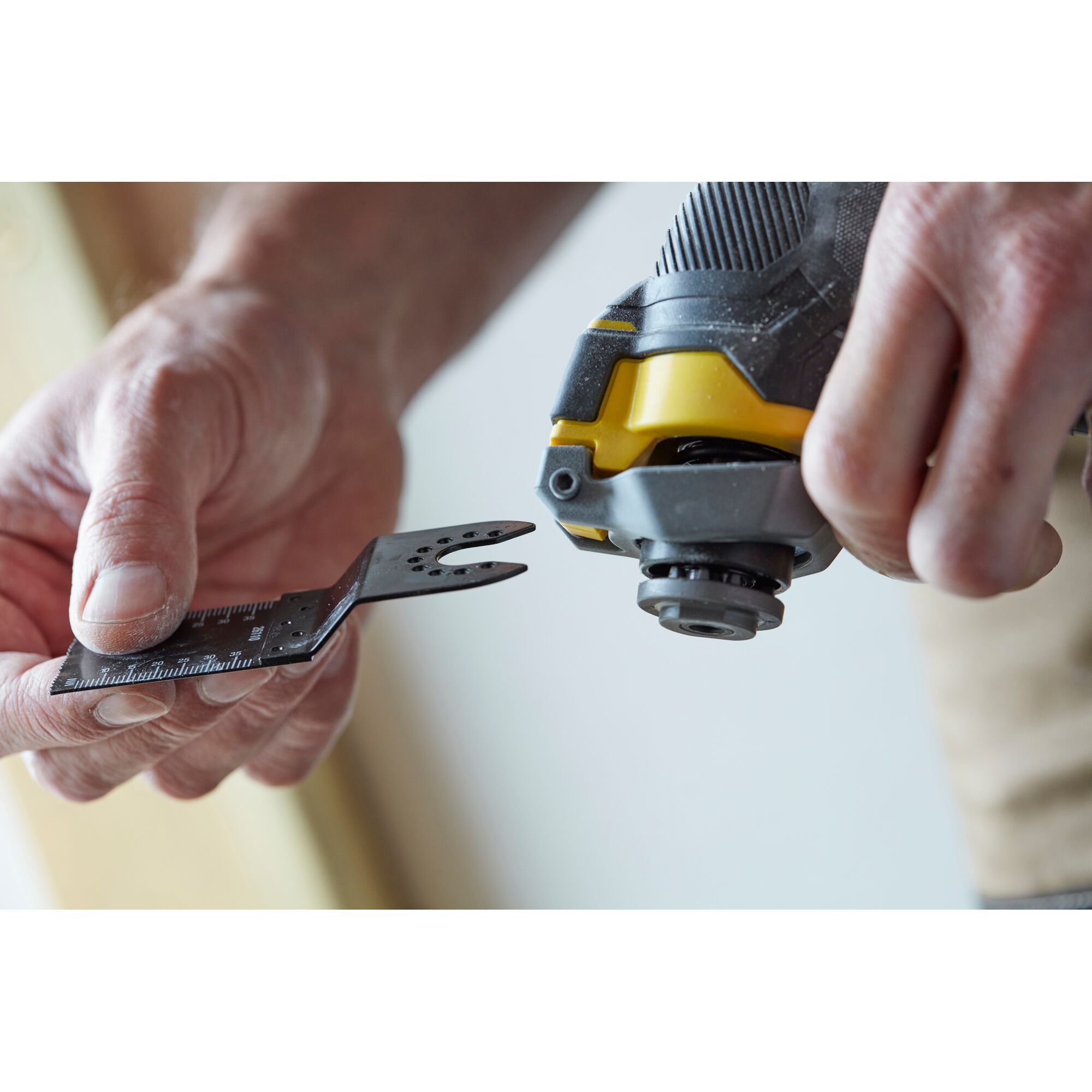 STANLEY SCT500D2K multitool blade attachment close-up, showing hand holding metal accessory.