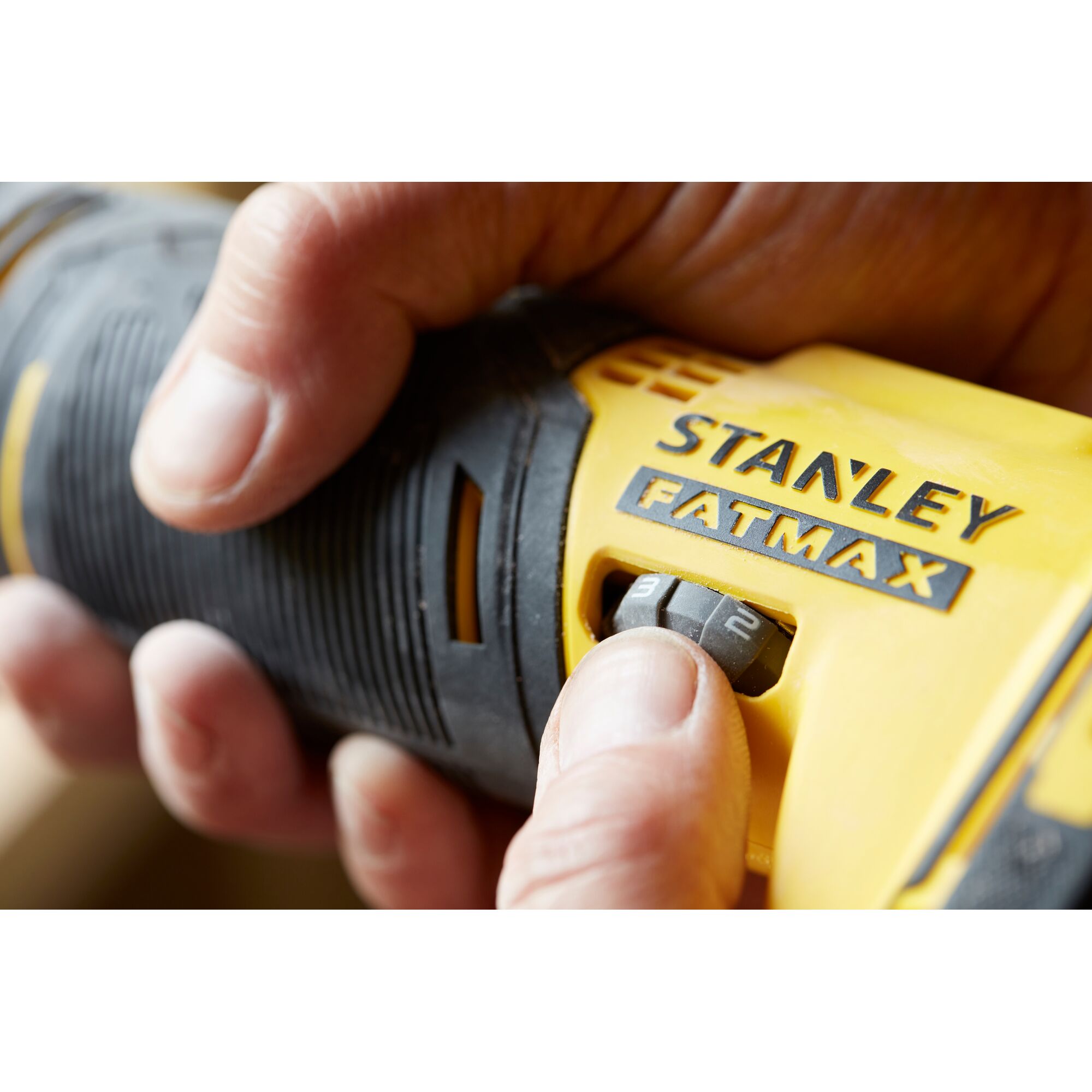 Photo of STANLEY SCT500D2K drill, close-up of hand adjusting speed dial, yellow and black handle.