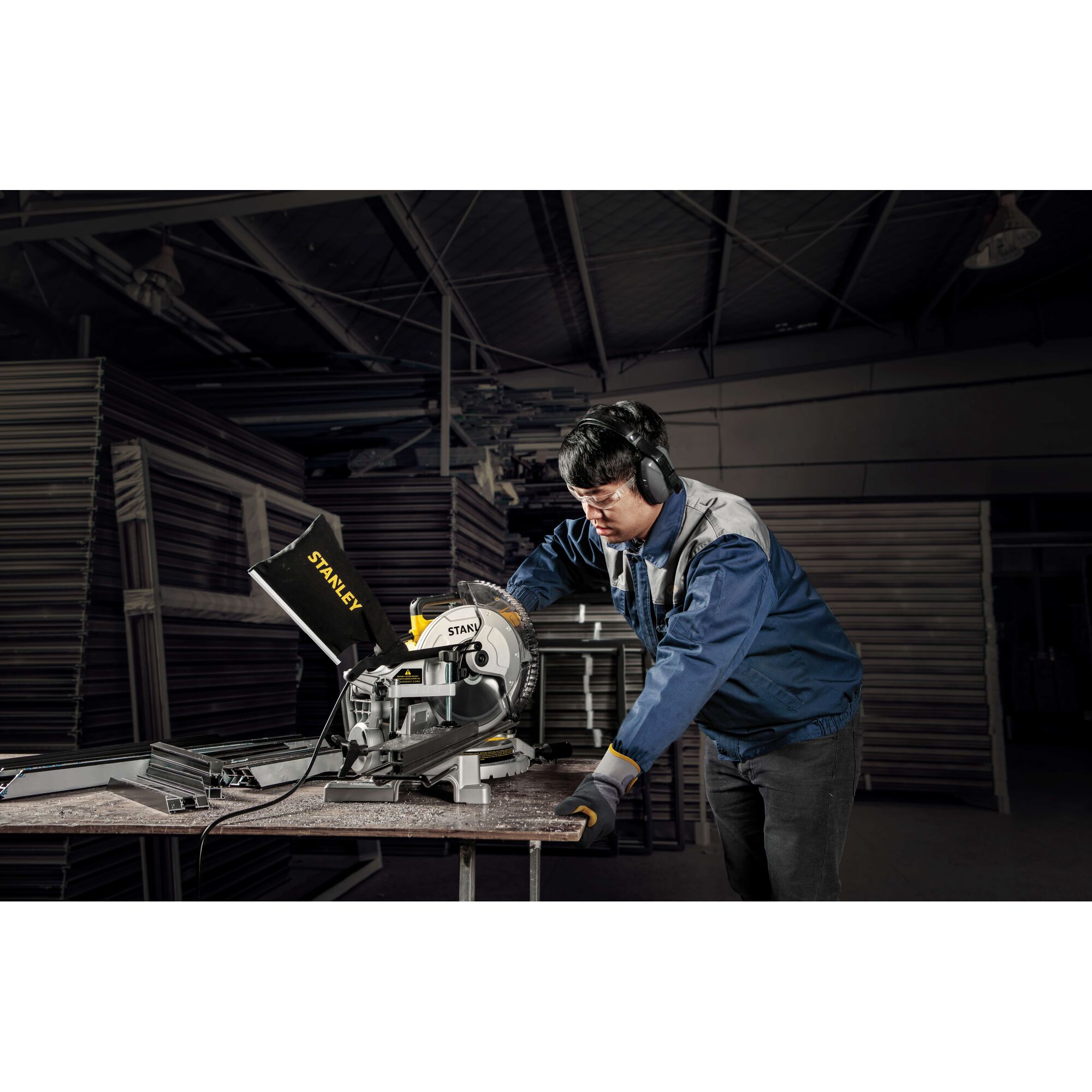 Photo of STANLEY SM16-B3 miter saw in use by worker in industrial workshop.