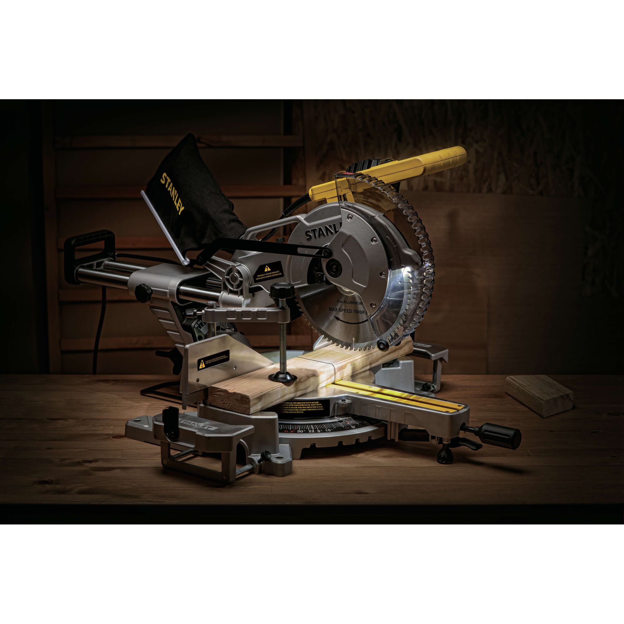 STANLEY SM18-B2C miter saw with sliding arm, angled blade, and dust bag on a wooden workbench.