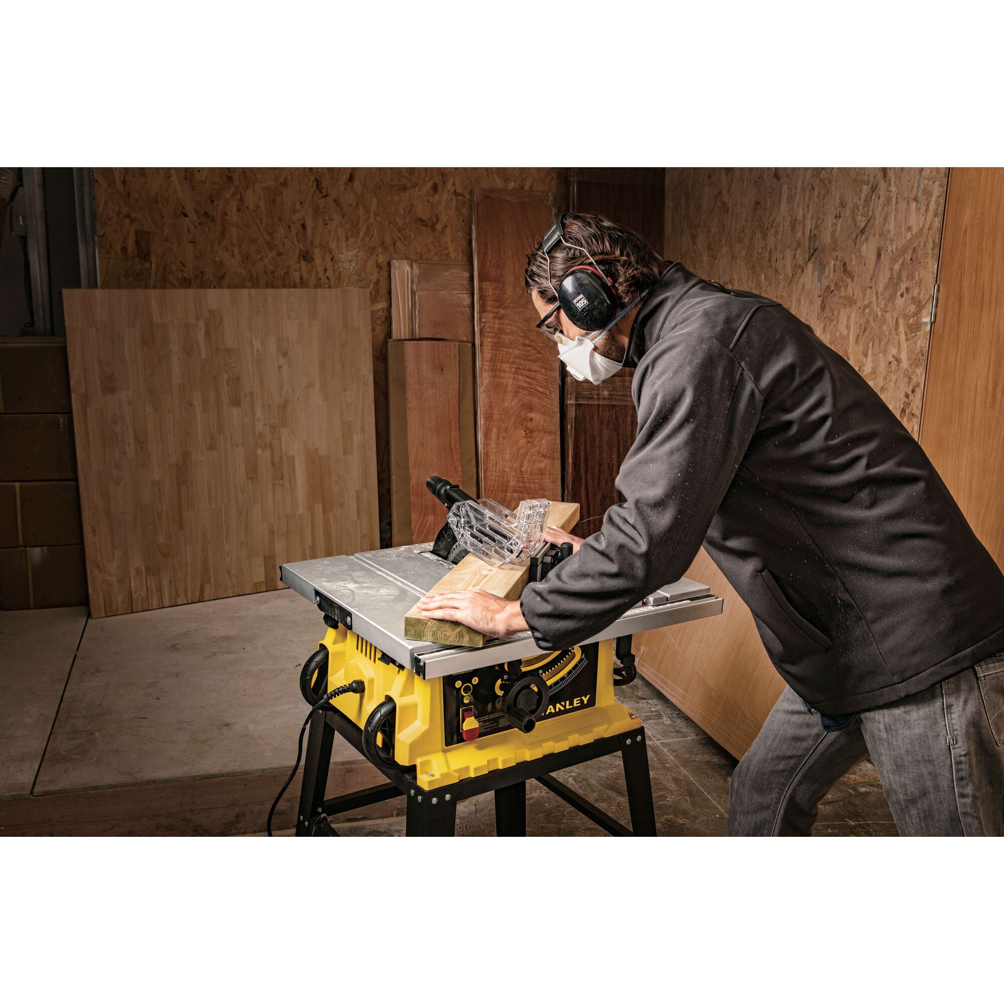 Stanley SST1801-B3 table saw in use, yellow body, wood cutting in workshop setting.