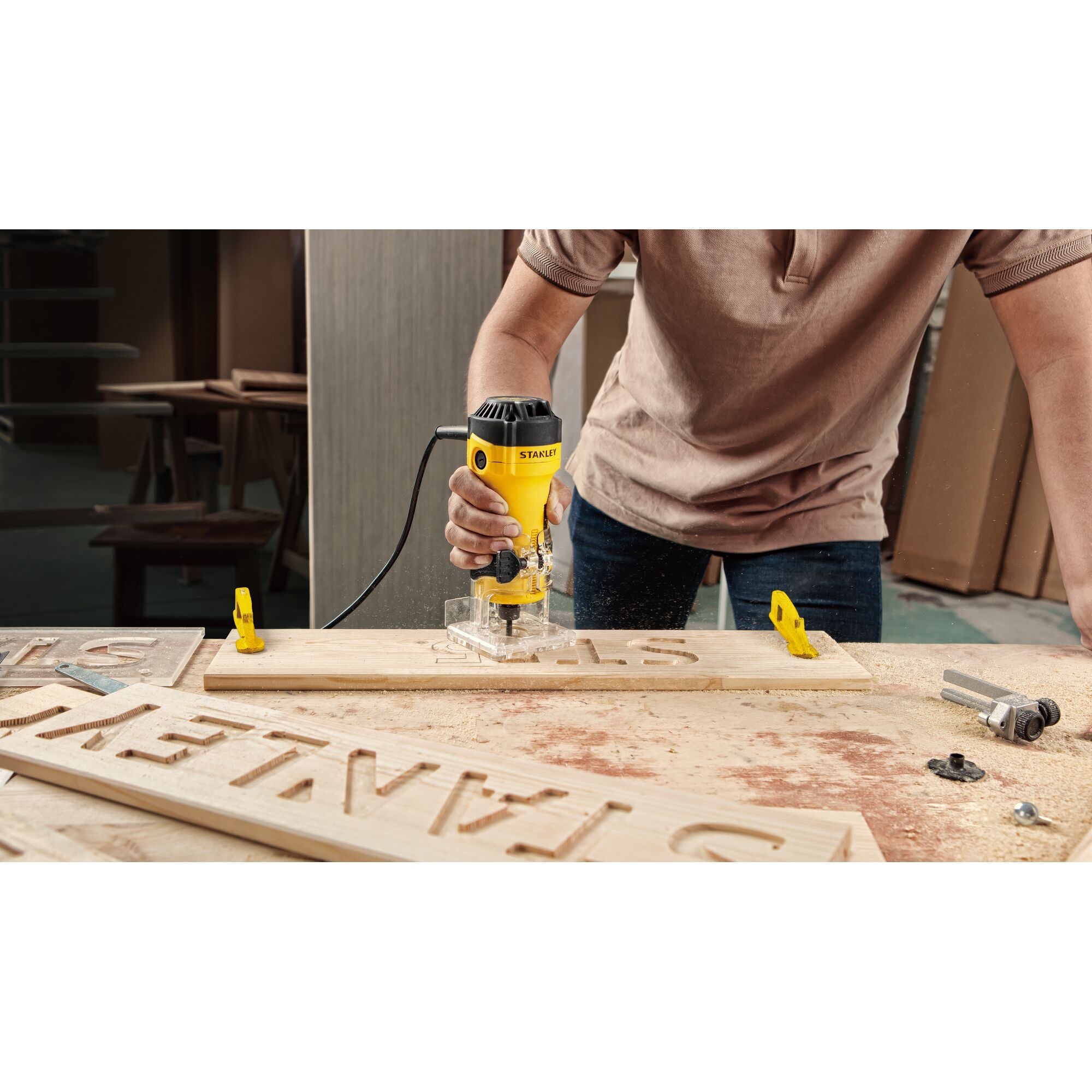 STANLEY ST55-B2 router used to carve letters into wood in a workshop setting.