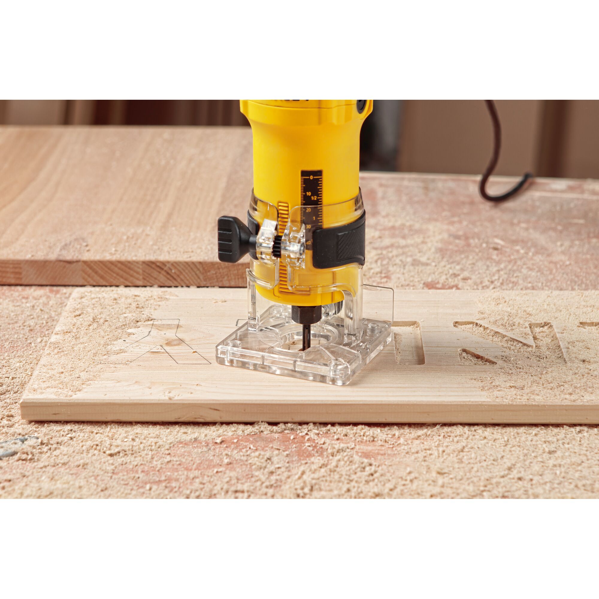 STANLEY ST55-KR compact router carving letters into wood, close-up side angle, woodworking photography.